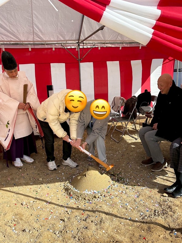 建築工房いろはが手掛ける注文住宅の地鎮祭で、施主と神職が鍬入れの儀を行い工事の無事を祈願している場面を写した写真で、家づくりの開始を示す工務店の施工前行事を客観的に示している。