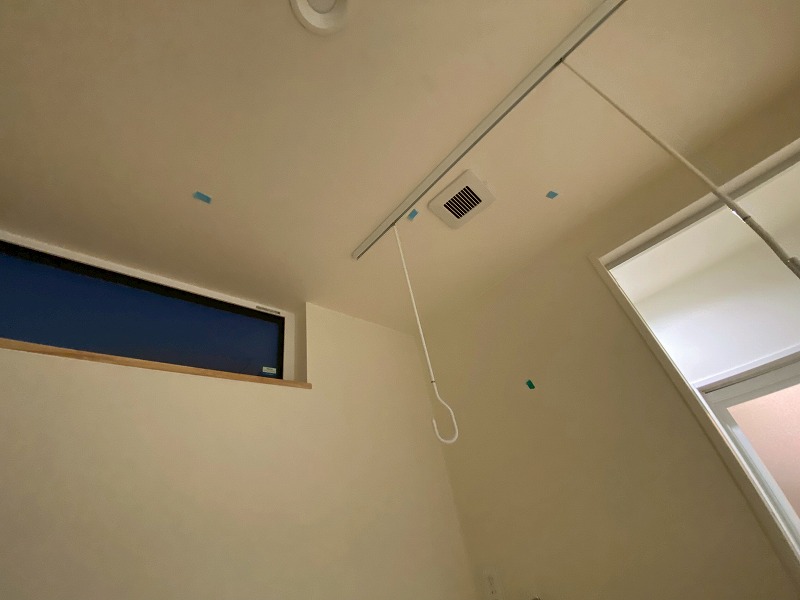 建築工房いろはの注文住宅における引渡し前検査の様子として、室内の天井や壁、換気口、物干し金物まわりに付いた細かな傷や汚れをマスキングテープで示しながら確認している場面を写した写真で、家づくりにおける工務店の品質管理工程を客観的に表している。