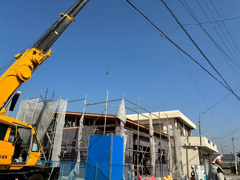 建築工房いろはによる注文住宅の上棟現場で、大型クレーンと足場が設置された構造体が家づくりの工程を示している。