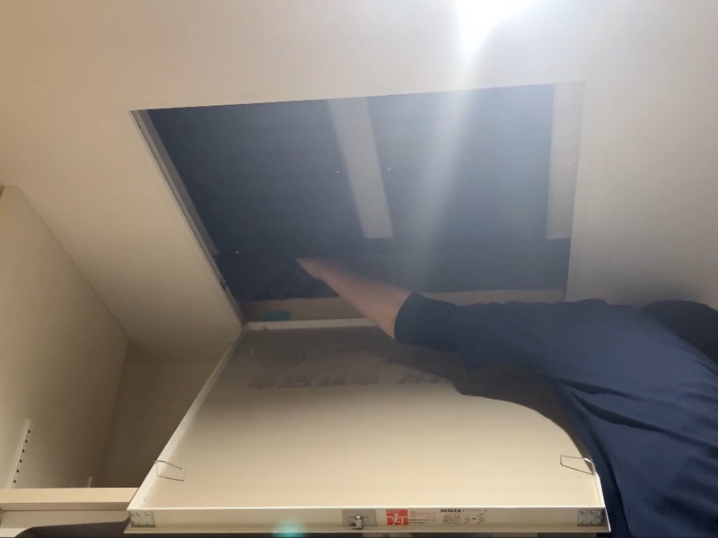 ALTテキスト（社名オプション：建築工房いろは）：
建築工房いろはが家づくりや注文住宅のメンテナンス工程として、室内の天井点検口を開けて手を伸ばしスイッチの操作をしている様子を写した写真で、住宅会社や工務店による住まいのメンテナンス作業を客観的に示す内容。