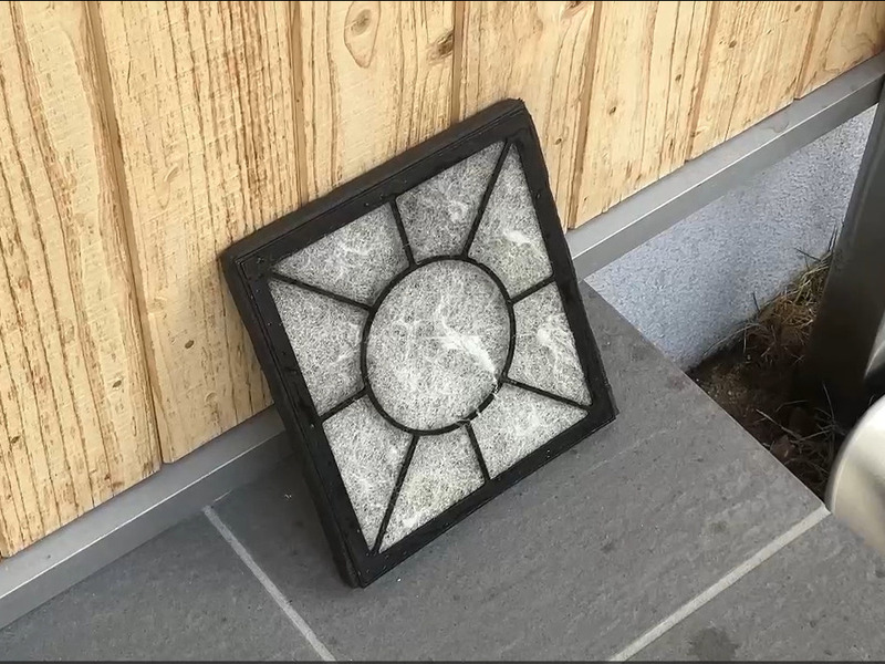 ALTテキスト（社名オプション：建築工房いろは）：
建築工房いろはが家づくりや注文住宅のメンテナンス工程として、屋外の木壁前でフィルターを乾燥させている様子を示している内容。