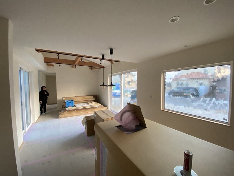 注文住宅の施工現場で、建築工房いろはが手がける天井梁、大開口窓などの内装仕上げが進む様子を撮影した写真で、家づくりにおける空間設計と工務店の施工品質が伝わる。