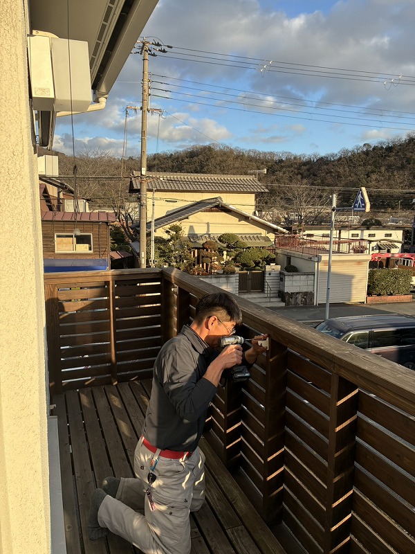 バルコニーで男性がアウターシェードの受け材を取付している様子を写した写真で、建築工房いろはが行う注文住宅の家づくりにおける日射遮蔽や外部空間の使い方の工夫を示している