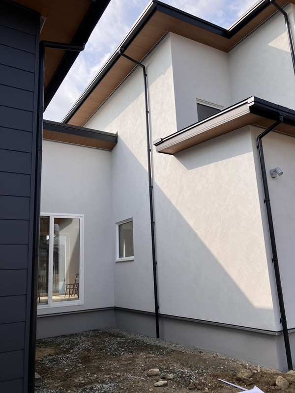 建築工房いろはが手掛けた注文住宅の外観を写した写真で、明るい外壁と深い軒天、雨樋、掃き出し窓などのディテールが分かる家づくりや工務店の施工事例として利用できる内容です。