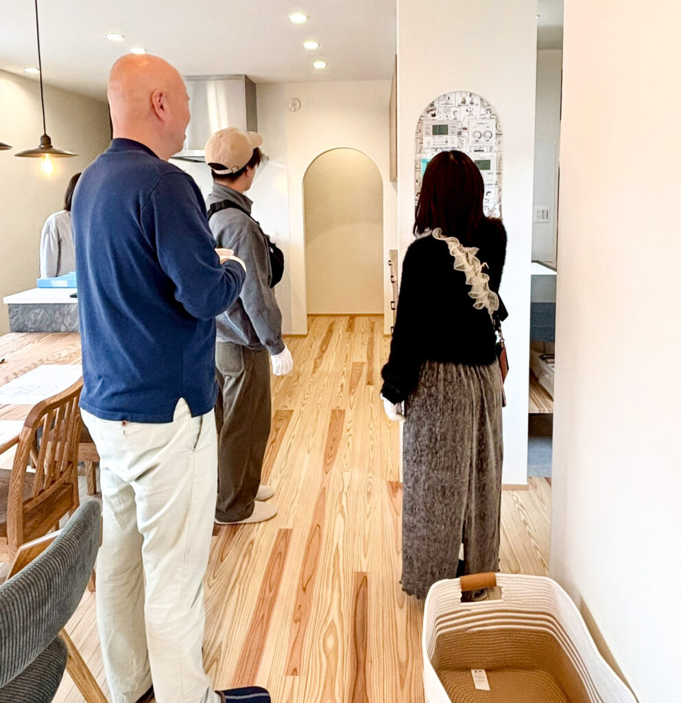 建築工房いろはが開催する注文住宅の完成見学会の室内写真で、来場者がLDKや間取りの動線を見学しながら家づくりについて説明を受けている相談風景。