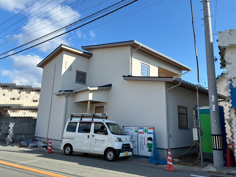 建築工房いろはが施工する注文住宅の現場を写した写真で、完成間近の外観と駐車中の作業車、安全表示が確認できる様子を客観的に示し、家づくりや工務店の施工状況を伝える内容。