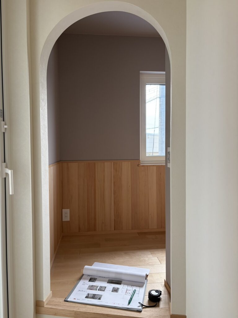 白の折れ戸で構成された大容量の壁面クローゼット。天井まで高さのあるハイドア仕様ですっきりとした印象を与え、内部には機能的な枕棚が設置されています。ナチュラルな無垢フローリングと調和する、清潔感のある収納空間です。