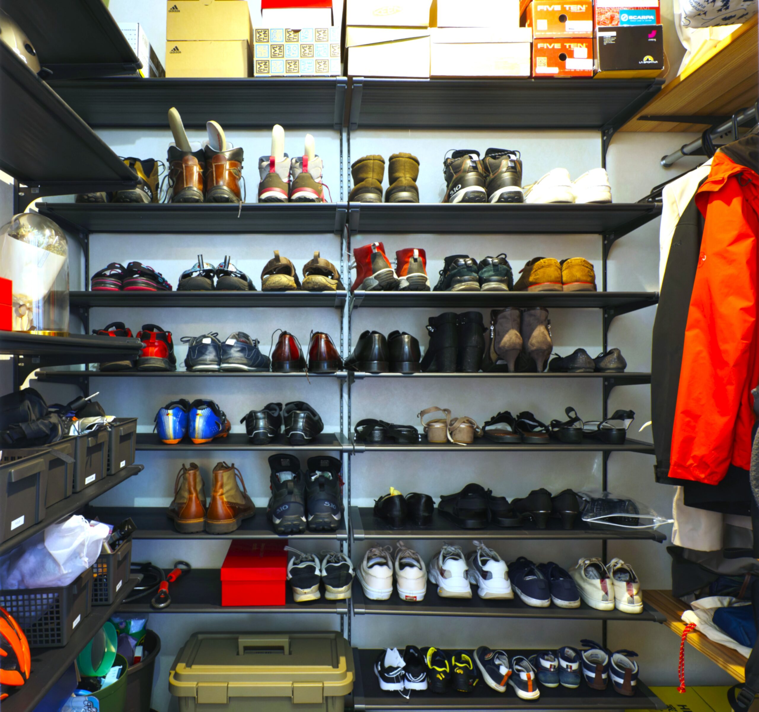 天井まで高さのある可動棚に、登山靴やスニーカー、サンダルが整然と並ぶ大容量のシューズクローク。上部には靴箱を収納し、サイドにはアウターを掛けられるハンガーパイプも備えた、機能的で収納力豊富な玄関収納です。