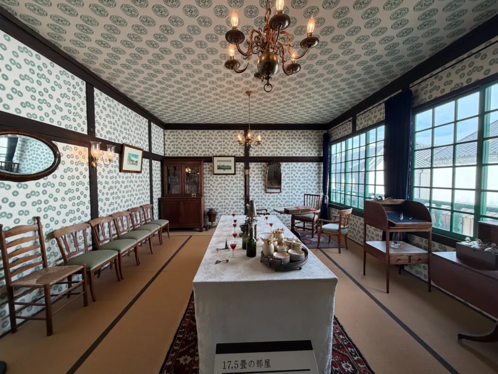 畳敷きの部屋に長テーブルや西洋アンティークの椅子、シャンデリアを配置した、クラシカルな花柄壁紙が印象的な和洋折衷の大広間