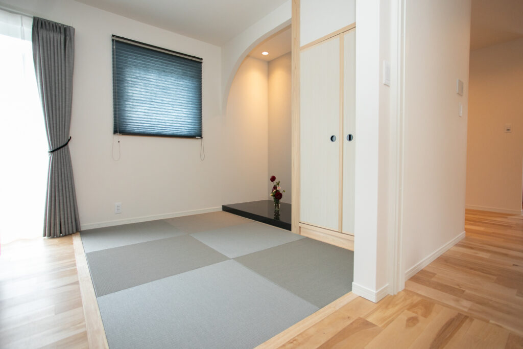 アール開口の床の間とグレーの琉球畳を組み合わせた、モダンで落ち着きのある和の趣を感じる小上がり空間。