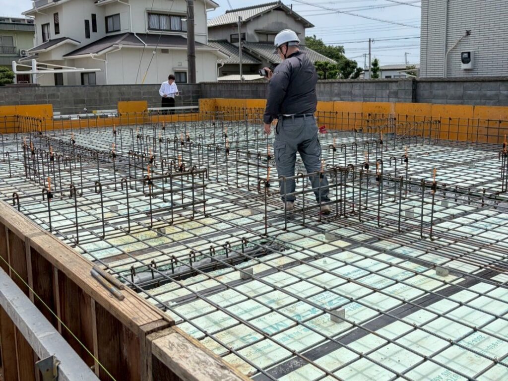 基礎工事の段階で、木製の型枠内に鉄筋が規則正しく組み上げられたベタ基礎の配筋風景。