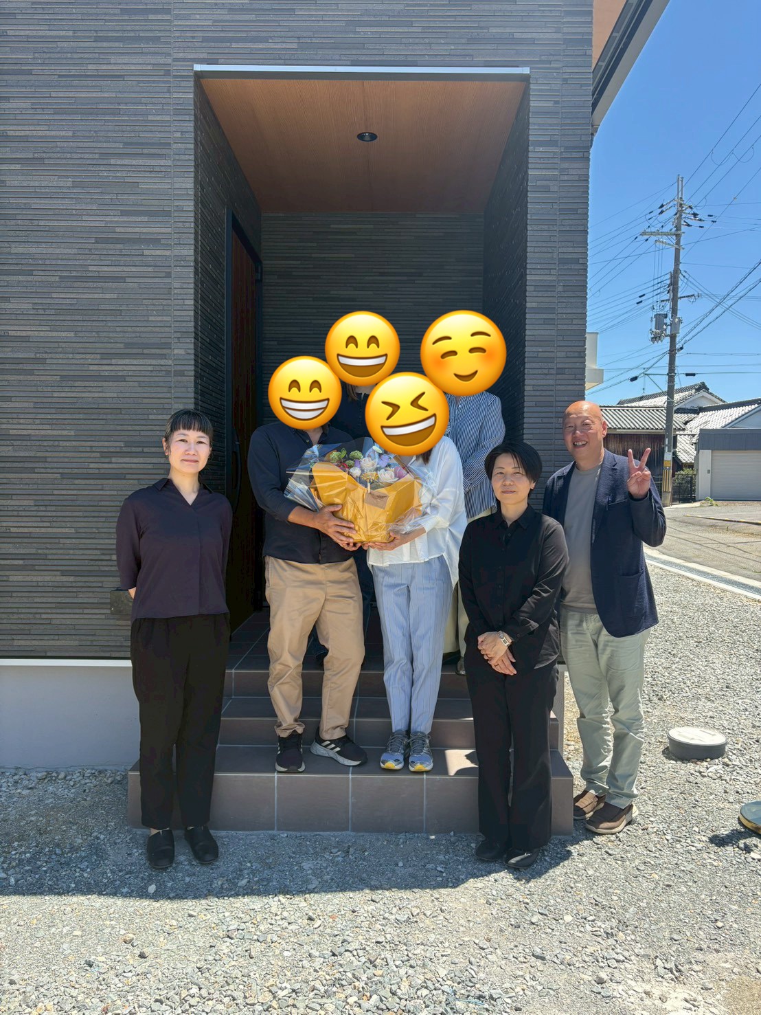 木目調のアクセントウォールとシックな黒い玄関ドアが印象的な、モダンで落ち着いた雰囲気の玄関ポーチ。