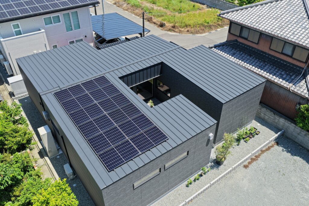 太陽光パネルを搭載したガルバリウム鋼板屋根と、中庭を囲むコの字型プランが特徴的なモダンな平屋
