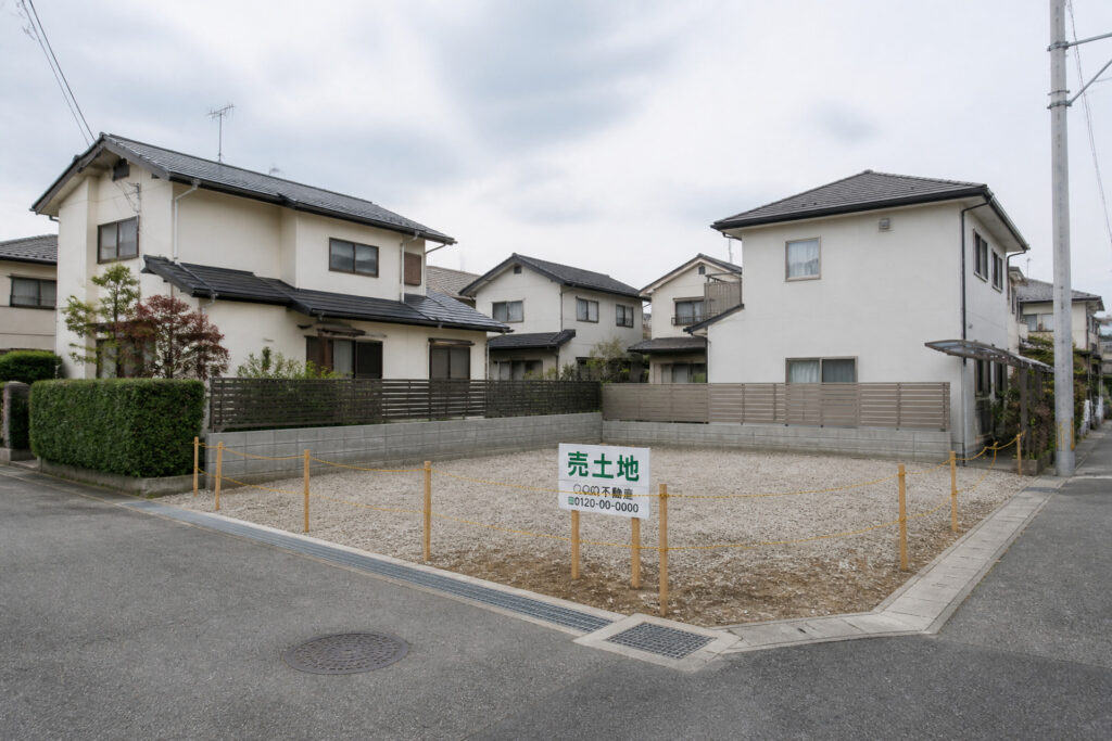 閑静な住宅街の一角にある「売土地」の看板が立てられた更地の様子を捉えた写真で、建築工房いろはが提案する注文住宅の土地探しや家づくりに最適な敷地風景。